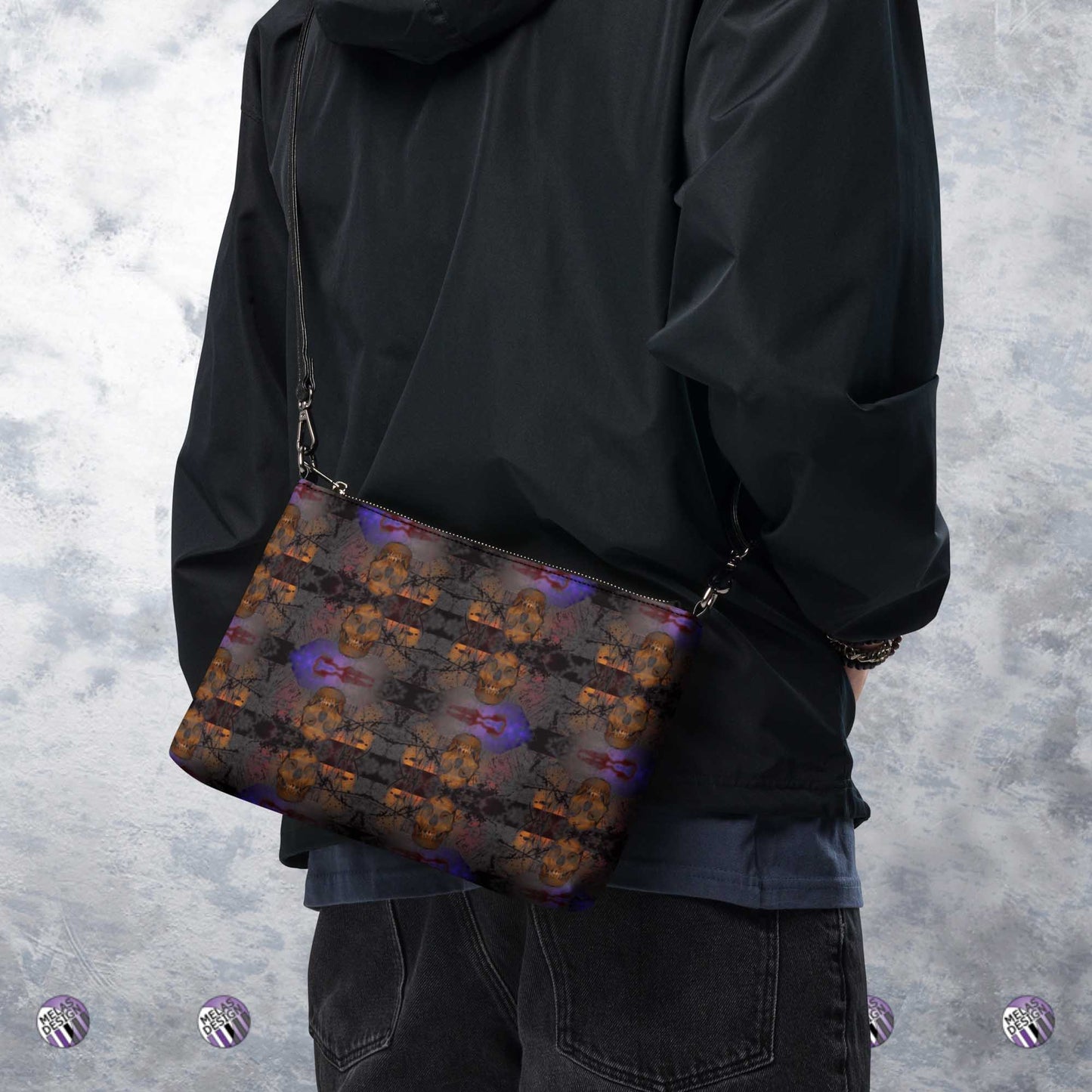 Grave Dirt Grotesque Skulls Cross-Body Bag; Product mockup worn cross-body by male model; Melasdesign logos