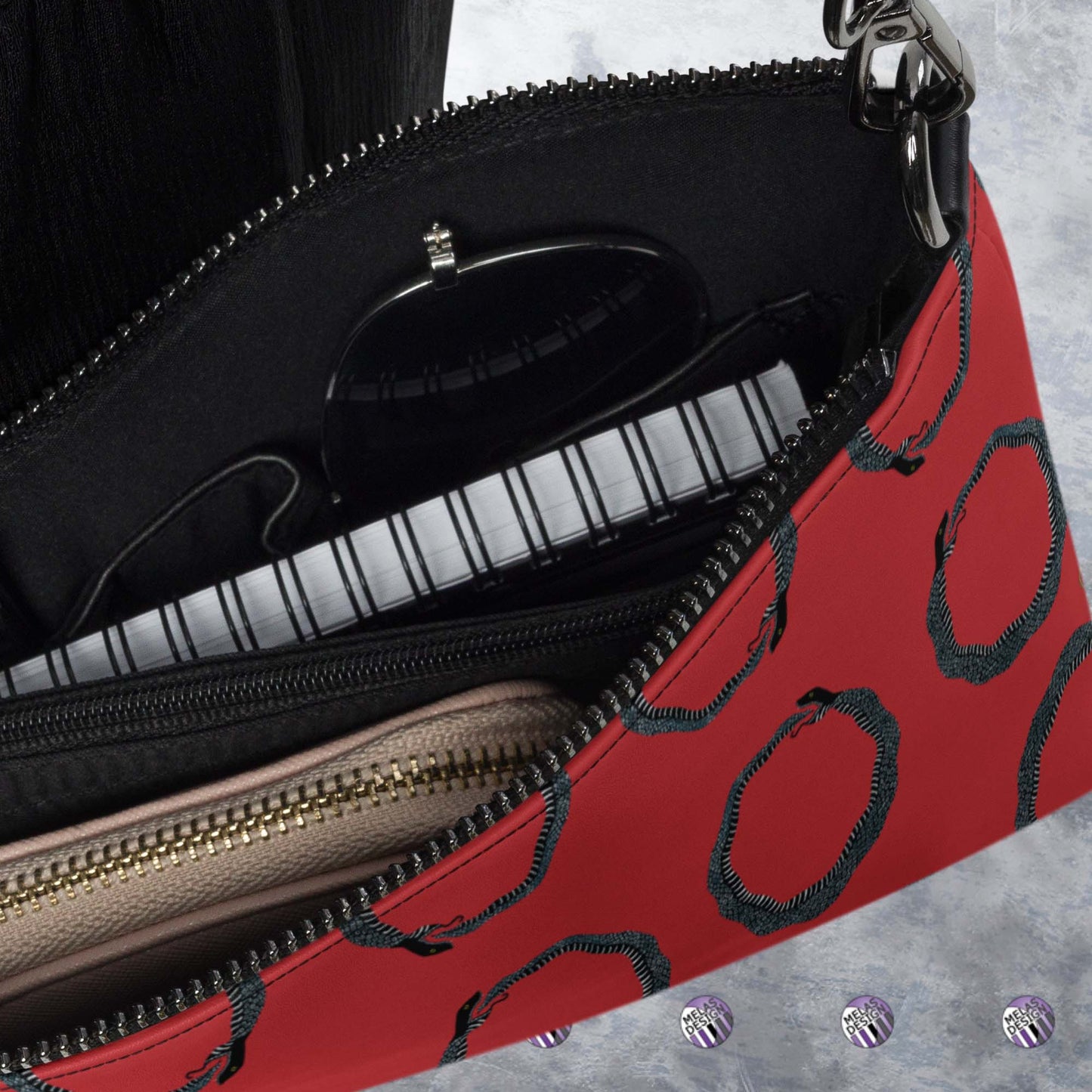 Ouroboros Infinity Cross-Body Bag Red Black; Product mockup interior detail filled with suggested items; Melasdesign logos