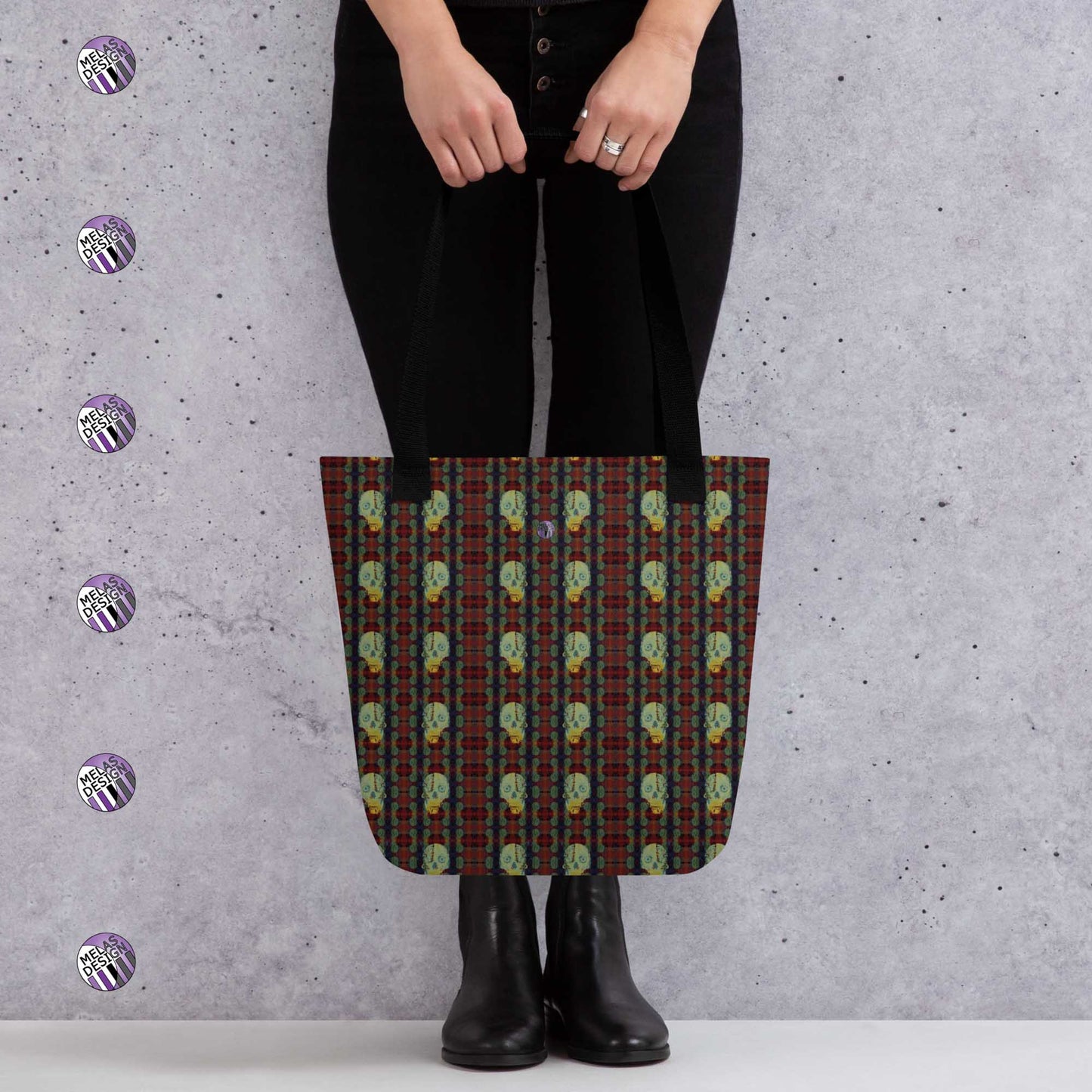 Paris Catacomb Vampire Skull Pattern Tote Bag; mock-up with model holding tote in front standing by gray wall with Melasdesign logos